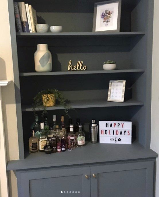 Fitted alcove unit with painted shelving above a cupboard
