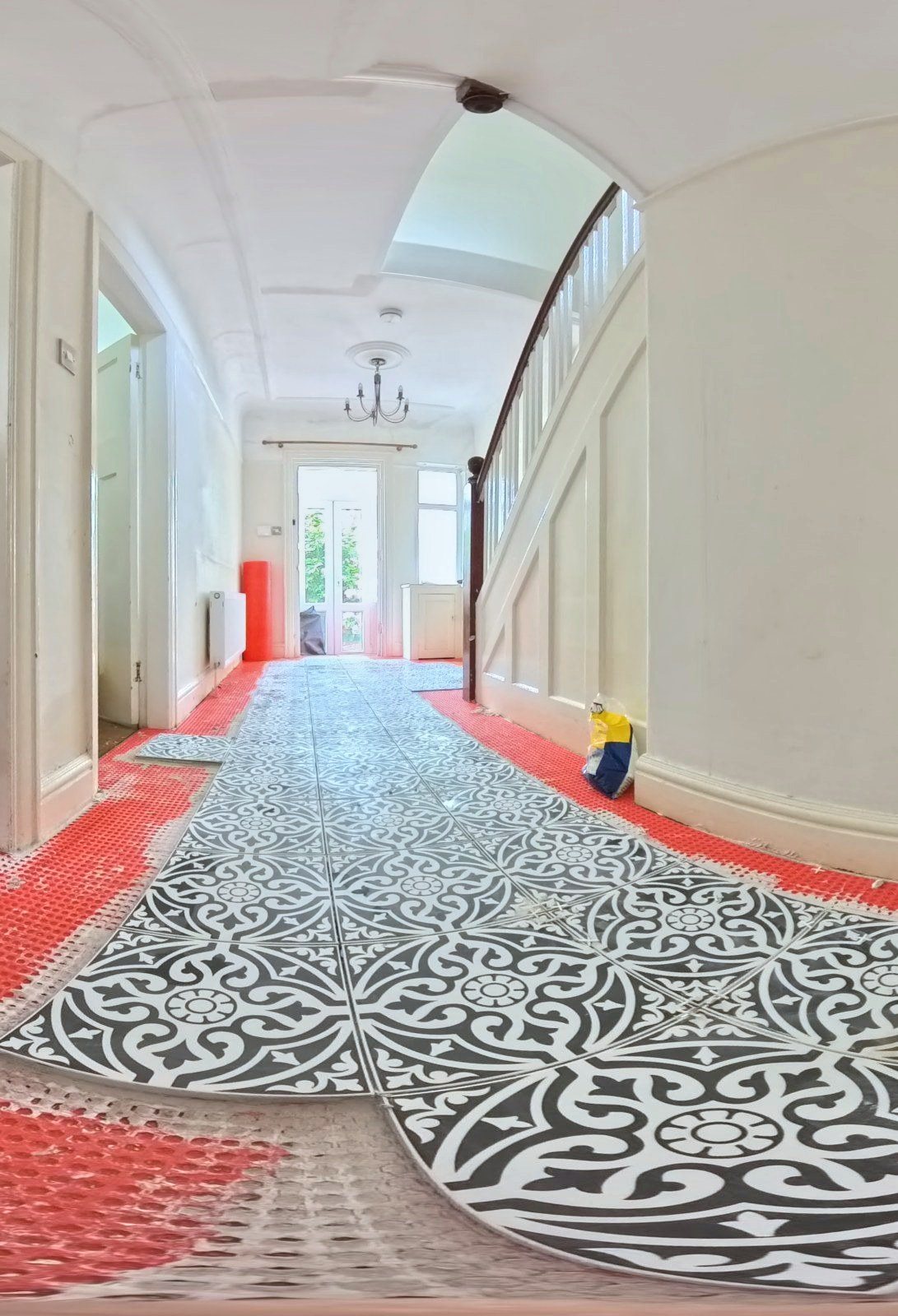 Hallway floor tiling laid over a red uncoupling membrane