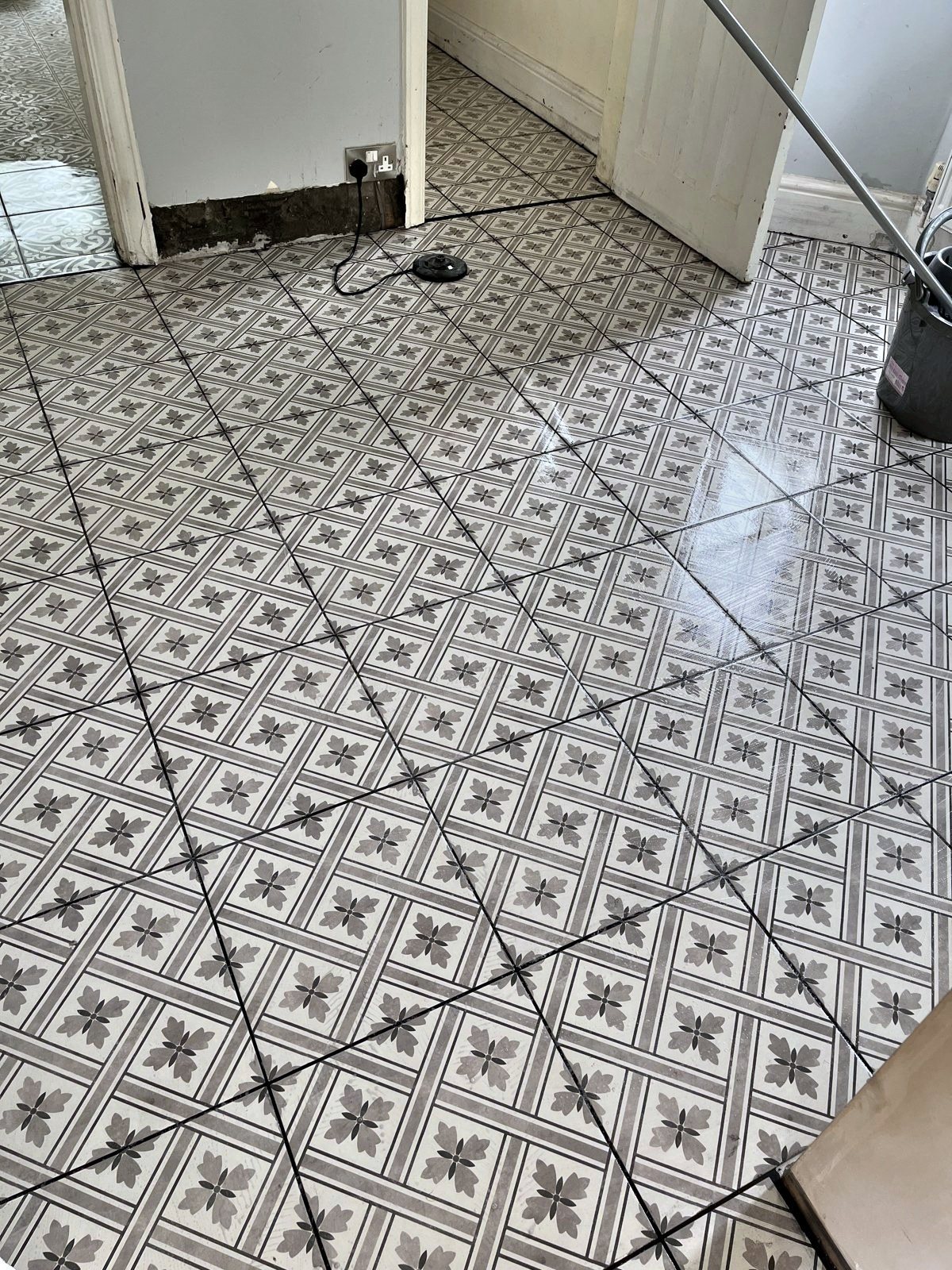 Grey patterned floor tiles laid on the diagonal